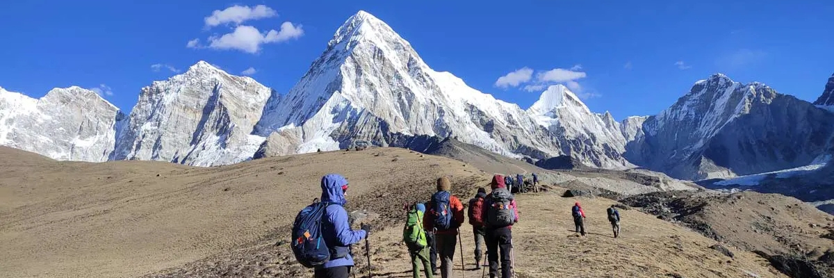 Trekker walking along a mountain trail with Everest in the background